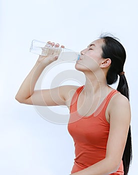 Thirsty fitness girl drinking bottle of water