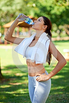 Thirsty for fitness. a young woman drinking water after a workout.