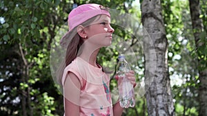 Thirsty girl drinking water in a park