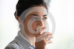 Thirsty healthy indian woman drinking fresh mineral pure water