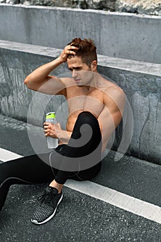 Thirsty Hot Man With Water Resting After Running Workout. Sports