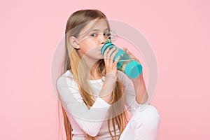 Thirsty kid drink water for health on pink background. Child hold water bottle. Little girl with plastic bottle. Thirst and dehydr