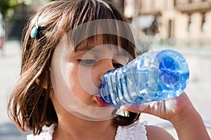 Thirsty little girl drinking water