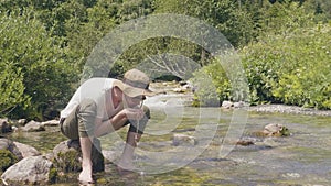 Thirsty man drinking spring water from hand while hiking mountain