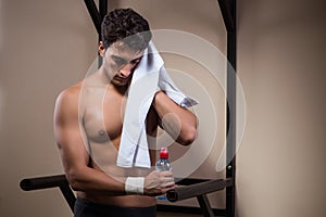 The thirsty man drinking water in sports gym