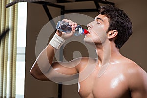 The thirsty man drinking water in sports gym