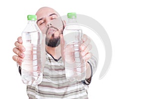 Thirsty man holding two bottles of cold water
