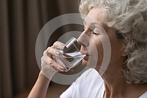 Thirsty mature woman having glass of water