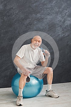 Thirsty senior man having rest after training