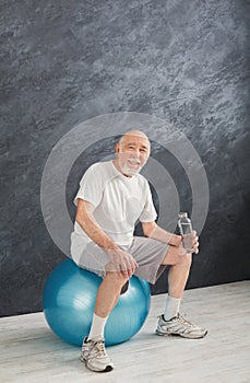 Thirsty senior man having rest after training