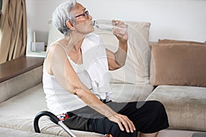 Thirsty senior woman suffering from heat,drinking fresh water from a bottle to quench their thirst in hot summer weather,high