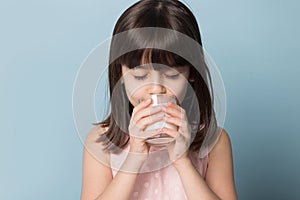 Thirsty six years old girl drinking glass of milk or yoghurt.