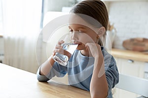 Thirsty small cute caucasian kid drinking water.