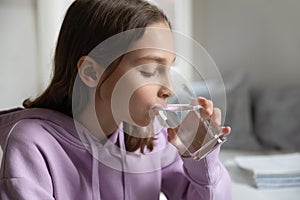 Thirsty teen girl drink water from glass