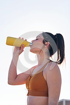 thirsty and tired runner drinking water outdoors