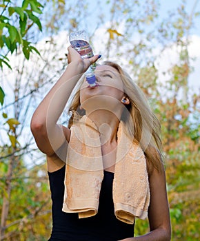 Thirsty woman athlete drinking