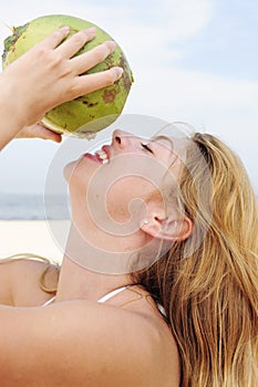 Thirsty woman drinking coconut water, close-up