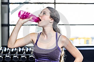 Thirsty woman drinking water on exercise ball