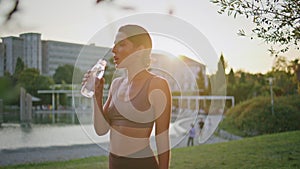 Thirsty woman drinking water fitness park workout closeup. Runner resting break