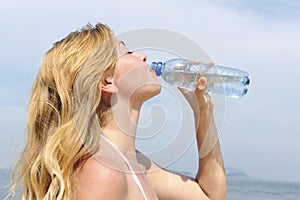 Thirsty woman drinking water outdoors