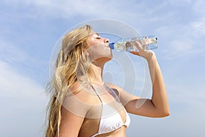 Thirsty woman drinking water outdoors