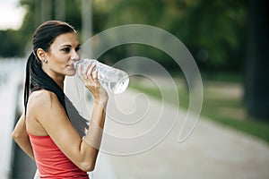 Thirsty woman drinking water to recuperate