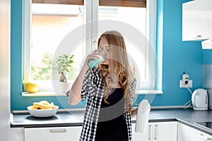 Thirsty young blond woman drinking milk