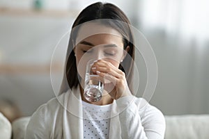 Thirsty young woman drink clean mineral water