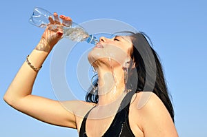 Thirsty young woman drinking cold water