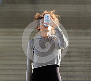 Thirsty young woman drinking from water bottle