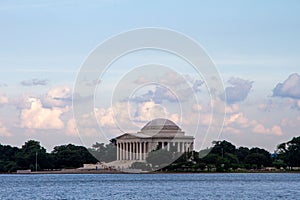 Thomas Jefferson monument in Washington DC from the water with trees and the sky in the background.