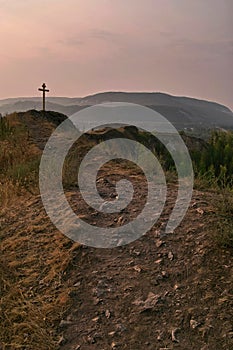 Thorny path to god. Stony path leading to the cross. Summer sunrise