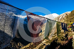 Thorung Phedi - Prayer flags with the view on first sunbeams in Himalayas