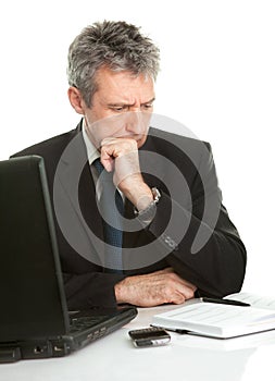 Thoughful business man working on laptop