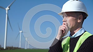 Thoughful engineer against wind turbine