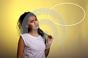 Thought cloud next to an asian girl which is dreaming. Thought process. Asian model with a curly hair on background with yellow