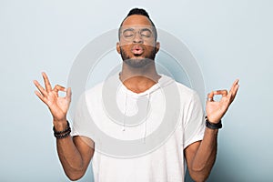 Thoughtful African American man practicing yoga with closed eyes