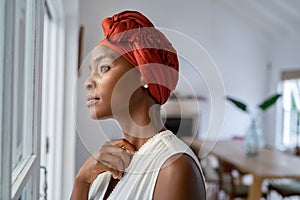 Thoughtful african woman thinking while looking outside the window