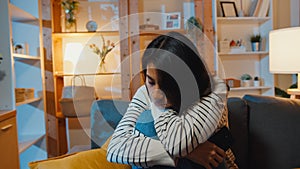 Thoughtful Asia lady suffering from insomnia sit at sofa in living room at house night with feel lonely, Sad depressed teenager