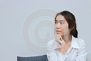 Thoughtful Asian business woman thinking about new idea with copy space background.