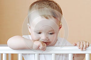 Thoughtful baby in white bed