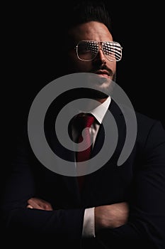 Thoughtful bearded businessman crossing arms and looking away