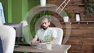 Thoughtful bearded young business man working on his computer