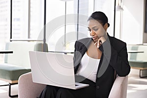 Thoughtful beautiful African business specialist woman using laptop