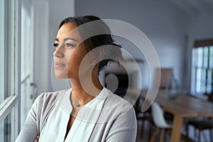 Thoughtful black woman looking outside window