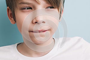 Thoughtful boy with bitter prank bitten his lower lip with his teeth and narrowed his eyes