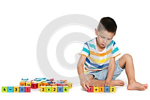 Thoughtful boy with blocks on the floor