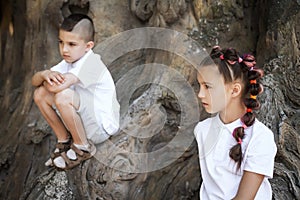 Thoughtful boy and girl by the tree