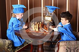 Thoughtful boys in blue suits play chess