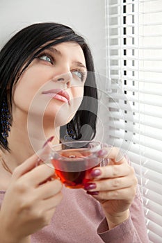 Thoughtful brunette girl drinking tea